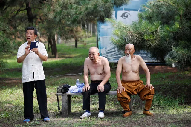 Kung Fu master Li Liangui (R) takes a break from his training Kung Fu with his friends at a park in Beijing, China, June 30, 2016. (Photo by Kim Kyung-Hoon/Reuters)