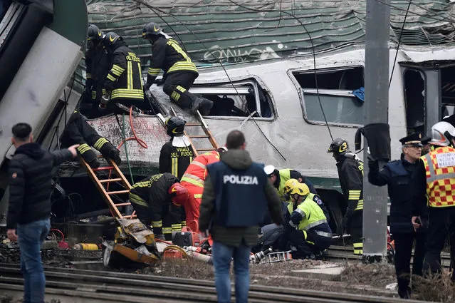 Fire fighters and police officers work around derailed trains in Pioltello, on the outskirts of Milan, Italy, January 25, 2018. (Photo by Reuters/Stringer)