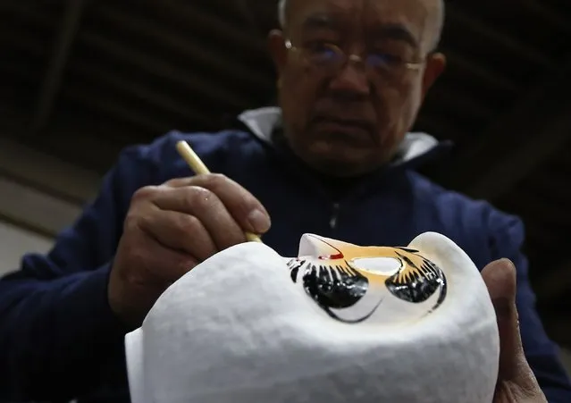 Japanese craftsman Sumikazu Nakata adds the final touches on a Daruma doll, which is believed to bring good luck, at his studio  “Daimonya” in Takasaki, northwest of Tokyo November 23, 2014. (Photo by Yuya Shino/Reuters)