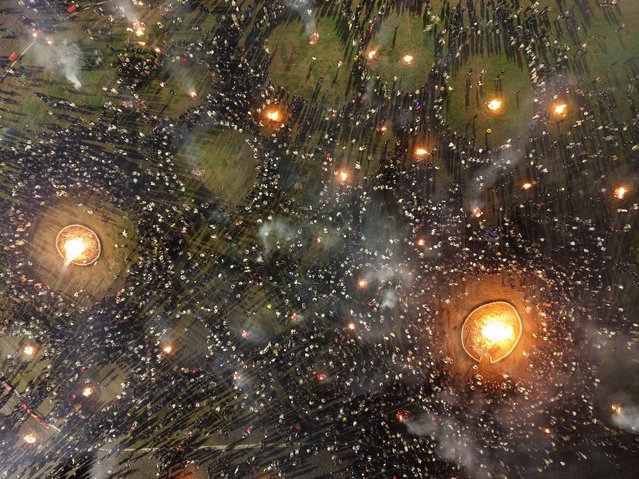 Aerial view of people circling around a bonfire to celebrate the Torch Festival on July 22, 2025 in Butuo County, Liangshan Yi Autonomous Prefecture, Sichuan Province of China. The Torch Festival is the biggest festival of people from the Yi ethnic group. (Photo by Luo Li/VCG via Getty Images)