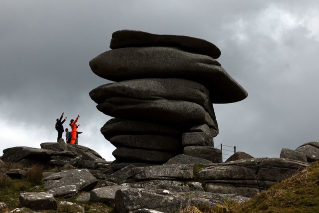 People react as they reach a natural structure known as The Cheesewring on Bodmin Moor, near the village of Minions, Cornwall, Britain on April 24, 2024. (Photo by Kevin Coombs/Reuters)