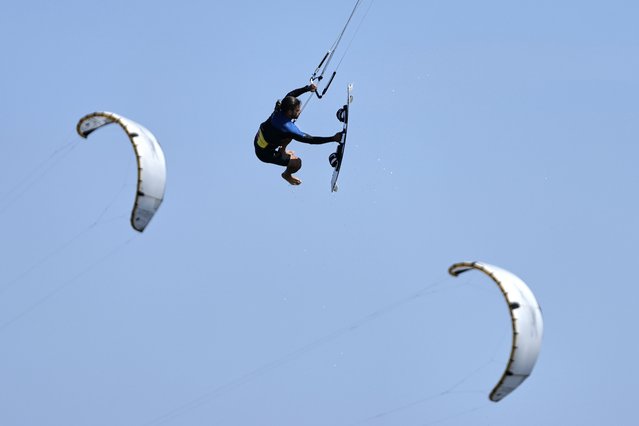 Kiteboarder Alexios Limperopoulos performs a jump during a windy day in Agios Nikolaos Artemida, east of Athens, Greece, Thursday, August 7, 2025. (Photo by Thanassis Stavrakis/AP Photo)