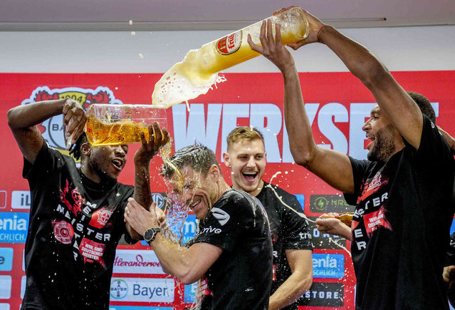 Leverkusen's head coach Xabi Alonso , centre, is sprayed with beer after Bayer Leverkusen won the German Bundesliga title beating Werder Bremen in Leverkusen, Germany, Sunday, April 14, 2024. (Photo by Martin Meissner/AP Photo)