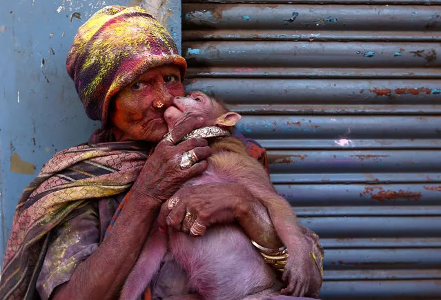 A woman daubed in colours kisses her monkey during Holi celebrations in Chennai, India on March 2, 2018. (Photo by P. Ravikumar/Reuters)