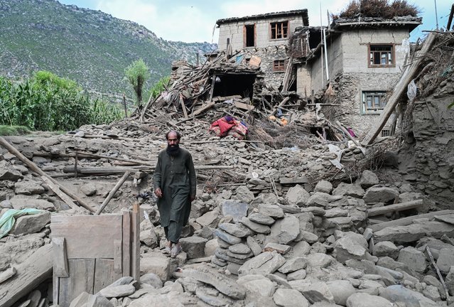 An man Afghan walks past a damaged house following earthquakes in the Mazar Dara village of Nurgal, a district of the Kunar Province, in Eastern Afghanistan, on September 1, 2025. (Photo by Wakil Kohsar/AFP Photo)