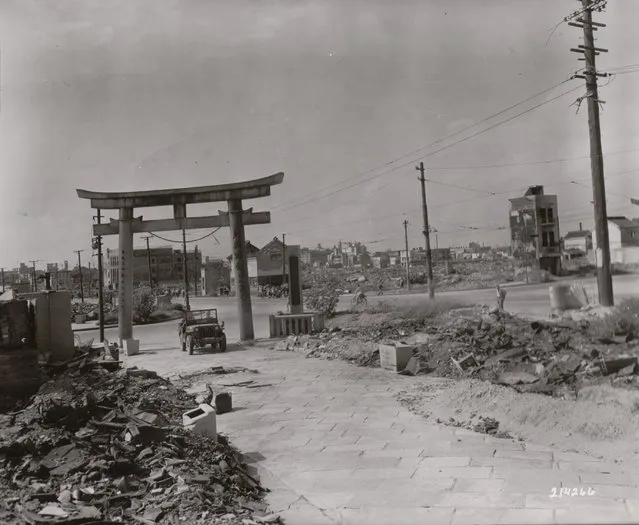 American soldiers drive a jeep through a Shinto arch and rubble in Osaka in September 1945. (Photo by National Archives and Records Administration)