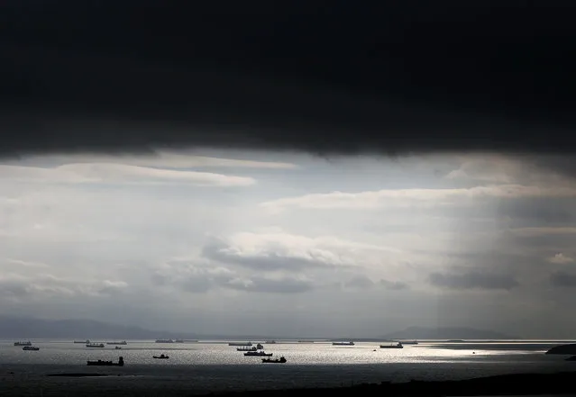 Cargo ships are seen sailing under storm clouds at open sea near the port of Piraeus, in Athens March 5, 2015. (Photo by Alkis Konstantinidis/Reuters)