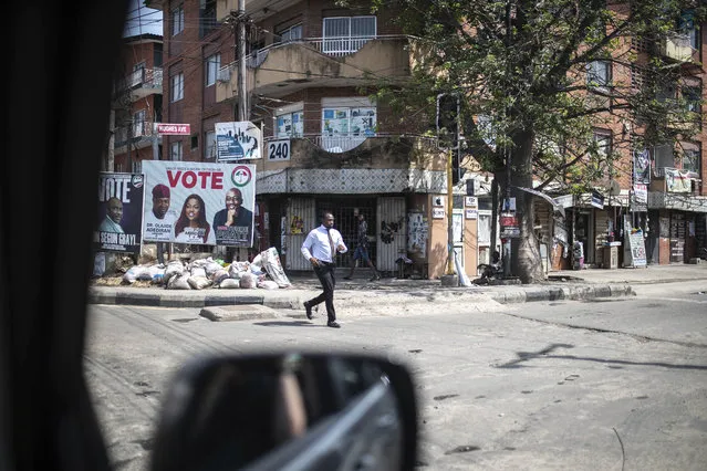 A man crosses a usually bustling avenue which had emptied as people anxiously wait for the results of the presidential elections, in Lagos, Nigeria, Tuesday, February 28, 2023. Tensions rose Monday during the counting of Nigeria's hotly contested presidential election when representatives from the parties of the two main opposition candidates walked out in anger from the center where state-by-state results were being announced. (Photo by Mosa'ab Elshamy/AP Photo)