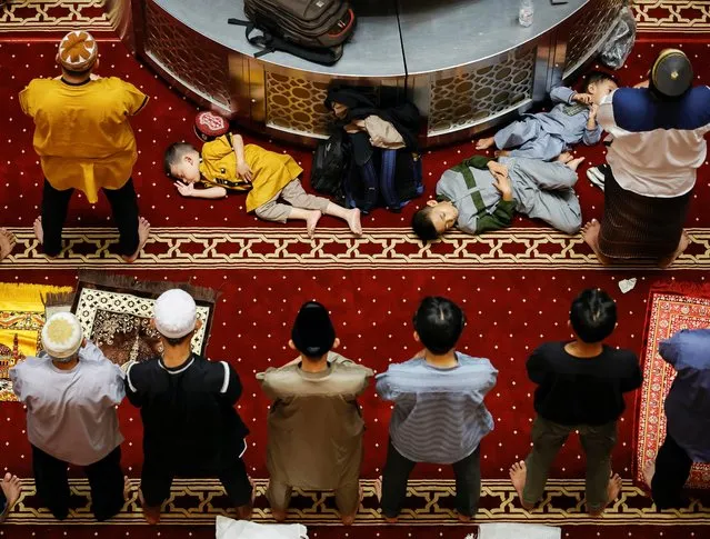 Children rest as Muslims offer “Tarawih” mass prayers during the first eve of holy fasting month of Ramadan at the Great Mosque of Istiqla in Jakarta, Indonesia on March 22, 2023. (Photo by Willy Kurniawan/Reuters)