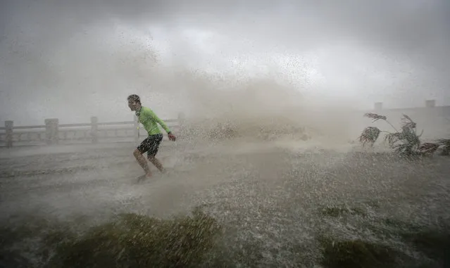 A man playing with waves runs way from a wave at a beach as Typhoon Sarika lands in Wanning, Hainan province, China, October 18, 2016. (Photo by Reuters/Stringer)