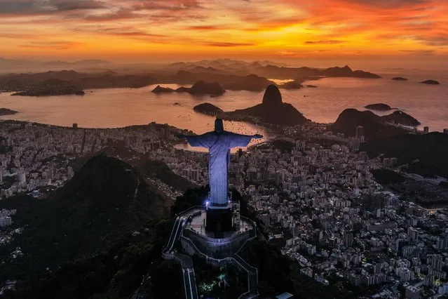 The sun rises in front of the Christ the Redeemer in Rio de Janeiro, Brazil on March 29, 2023. (Photo by Carl de Souza/AFP Photo)