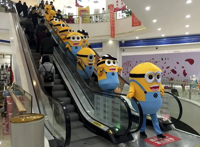 People dressed as minions from the film "Minions" take an escalator during a promotional event at a department store in Wuhan, Hubei province, China, November 14, 2015. (Photo by Reuters/Stringer)