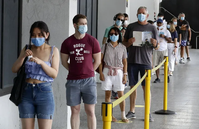 People wait in a line at a COVID-19 testing station on the northern beaches in Sydney, Australia, Monday, December 21, 2020. Sydney's northern beaches are in a lockdown similar to the one imposed during the start of the COVID-19 pandemic in March as a cluster of cases in the area increased to more than 80. (Photo by Mark Baker/AP Photo)