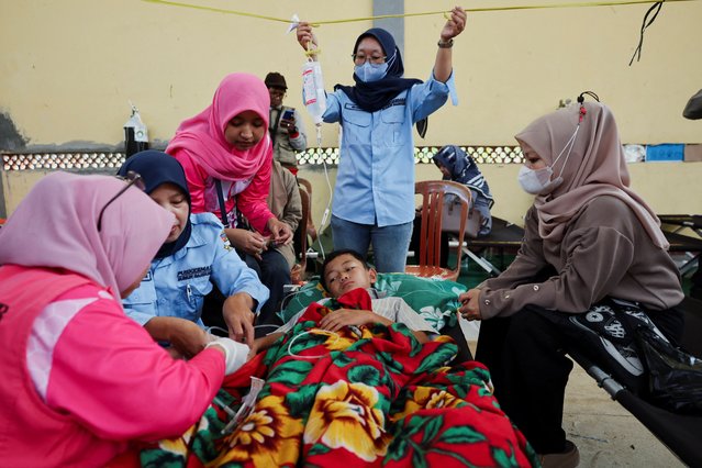 Muhammad Setiawan Pratama, 11, an elementary student receives treatment for food poisoning after eating government-sponsored free school meals, at a makeshift clinic inside a district's hall in Bandung, West Java province, Indonesia, on September 25, 2025. (Photo by Willy Kurniawan/Reuters)
