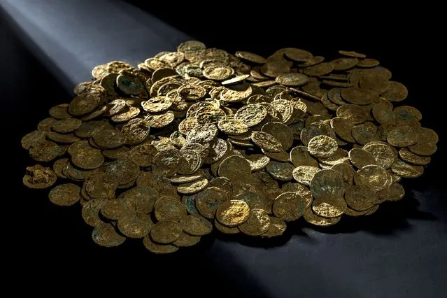 This handout picture released on November 19, 2015 by the Archaeological Service of the Canton of Aargau shows a treasure of coins found in Ueken, Northern Switzerland. A Swiss gardener accidentally discovered in his orchard planted with cherry trees a true numismatic treasure buried for 1,700 years, dating from the 3rd century AD. (Photo by AFP Photo)