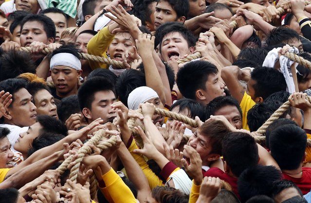 Devotees pull a carriage carrying the Black Nazarene with a rope during the annual procession in Manila, January 9, 2015. (Photo by Erik De Castro/Reuters)