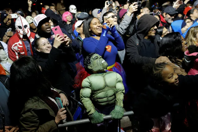 A child dressed as The Incredible Hulk watches participants in the Greenwich Village Halloween Parade in Manhattan, New York, U.S., October 31, 2016. (Photo by Andrew Kelly/Reuters)