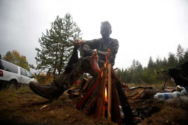 Members of the Oath Keepers and general public rest and warm up by the fire during a tactical training session in northern Idaho, U.S. October 1, 2016. (Photo by Jim Urquhart/Reuters)
