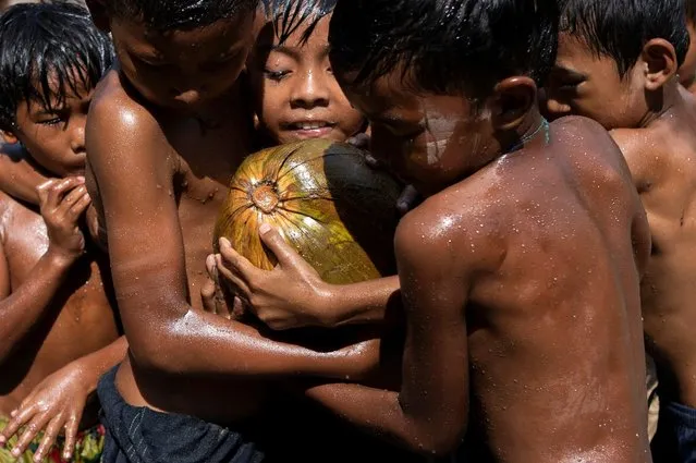 Children play with an oiled coconut during Myanmar's 73rd Independence Day celebrations amid the spread of the coronavirus disease (COVID-19) in Yangon, Myanmar, January 4, 2021. (Photo by Shwe Paw Mya Tin/Reuters)