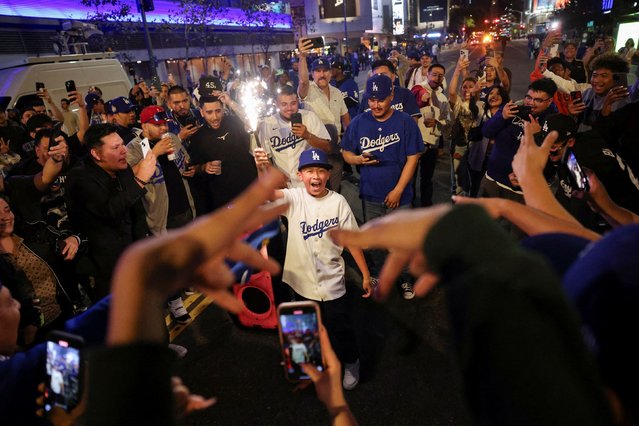 Baseball fans celebrate on the street after the Los Angeles Dodgers' victory over the New York Yankees to win the World Series in Los Angeles, California, U.S., October 30, 2024. (Photo by Daniel Cole/Reuters)