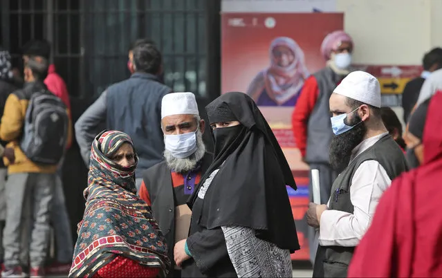 People wearing face masks as a precaution against the coronavirus wait outside a government hospital in Jammu, India, Tuesday, February 16, 2021. (Photo by Channi Anand/AP Photo)