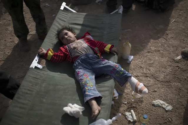 A girl, injured by fighting between the Iraqi forces and Islamic State militants, rests after receiving treatment on her foot at a field hospital in eastern Mosul, Iraq, Sunday, November 13, 2016. Iraqi forces battled waves of suicide car bombs on Sunday as they attempt to advance deeper into eastern Mosul, defended by militants from the so-called Islamic State group. (Photo by Felipe Dana/AP Photo)
