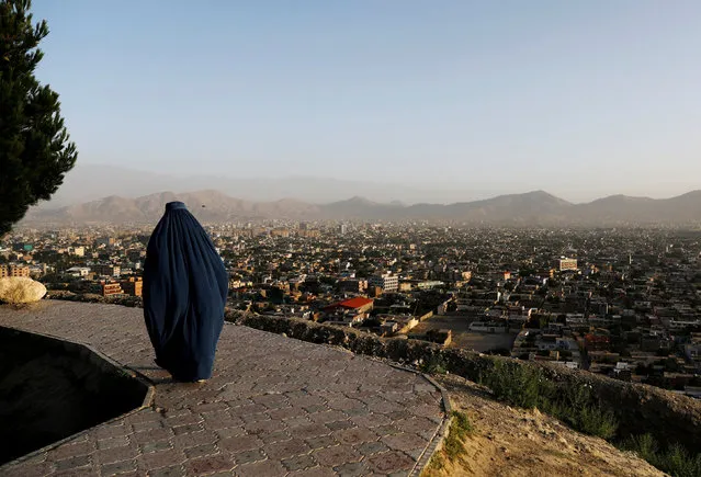 An Afghan woman walks on a hilltop overlooking Kabul, Afghanistan June 25, 2018. (Photo by Mohammad Ismail/Reuters)