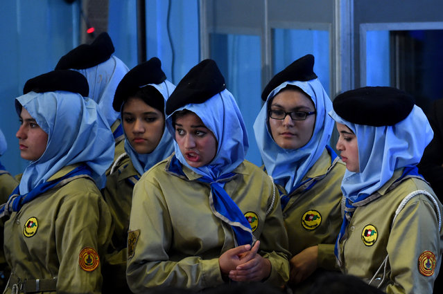 Afghan students look on during a ceremony attended by Afghan President Ashraf Ghani marking the start of the new school year at Amani High School in Kabul on March 19, 2015. President Ghani said deprivation of children from school and closure of schools are enmity against Islam and Afghanistan. Over 8 million Afghans are going to schools, and 42 percent of them are girls, a great achievement for Afghan girls as they were banned during the Taliban regime before 2001. (Photo by Wakil Kohsar/AFP Photo)