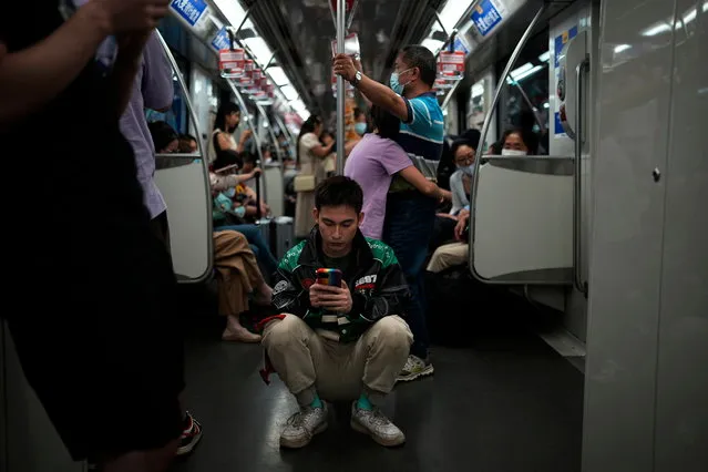 V J Kawakubo, 30, an IT programmer, checks his phone on a subway train in Shanghai, China on June 3, 2023. (Photo by Aly Song/Reuters)
