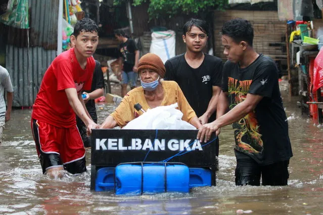 Youths transport an elderly woman using a makeshift raft in an area affected by floods following heavy rains in Jakarta, Indonesia, February 18, 2021. (Photo by Ajeng Dinar Ulfiana/Reuters)