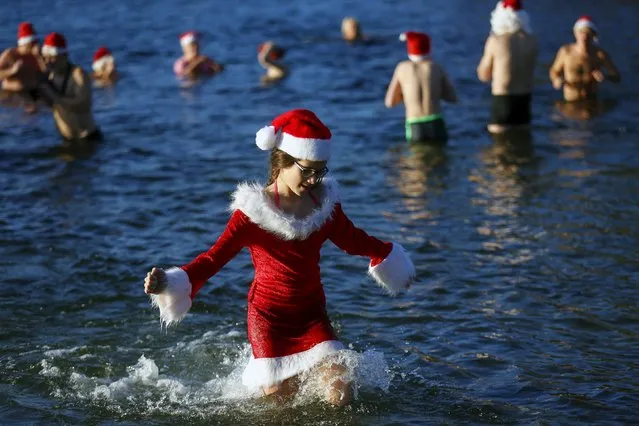 Members of the ice swimming club “Berliner Seehunde” (Berlin Seals) take a dip in the Orankesee lake as part of their traditional Christmas swimming session in Berlin, Germany, December 25, 2015. (Photo by Hannibal Hanschke/Reuters)