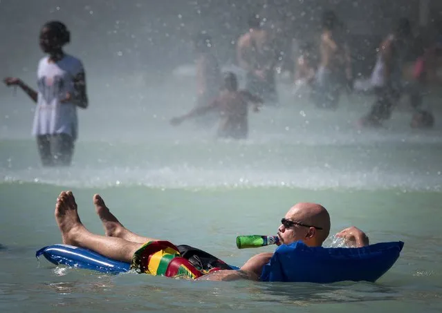 People cool themselves at The Trocadero Fountain in Paris on August 2, 2018, as a heatwave continues across northern Europe. Some 66 of French departments are affected by the current heatwave and have been placed on “orange” alert by authorities in the face of unprecedented high temperatures, which should “persist until the middle of next week” according to meterological sources. (Photo by Gerard Julien/AFP Photo)