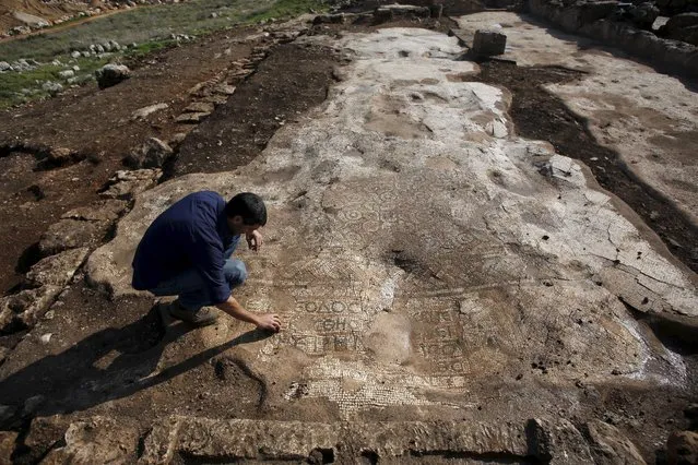 Amit Shadman, excavation director on behalf of the Israel Antiquities Authority (IAA), touches a mosaic floor which was revealed during excavations in Rosh Ha'ayin, east of Tel Aviv, Israel December 30, 2015. (Photo by Baz Ratner/Reuters)