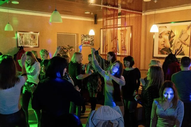 Women dance in a restaurant during a corporate celebration of International Women's Day in Kurahove, eastern Ukraine, Friday, March 5, 2021. (Photo by Evgeniy Maloletka/AP Photo)