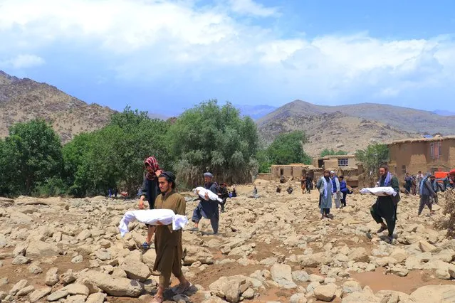 Afghan residents carry the bodies of children, who died in flash floods in the Jalrez district of Maidan Wardak province on July 23, 2023. The death toll from overnight flash floods caused by torrential rain in central Afghanistan has risen to 26, with more than 40 people missing, officials said. (Photo by AFP Photo/Stringer)