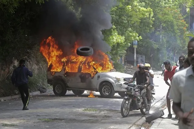 A vehicle set fire by protesters burns during a demonstration against insecurity in Port-au-Prince, Haiti, Monday, August 7, 2023. (Photo by Joseph Odelyn/AP Photo)