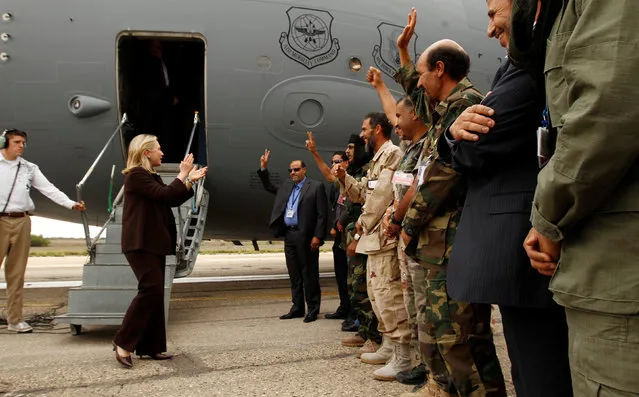 Former U.S. Secretary of State Hillary Clinton meets soldiers at the steps of her C-17 military transport aircraft upon her arrival in Tripoli October 18, 2011.  Clinton arrived in Libya on Tuesday to meet the new leaders Washington helped into power, while die-hard forces loyal to Muammar Gaddafi launched a surprise counter-attack in his hometown of Sirte. (Photo by Kevin Lamarque/Reuters)