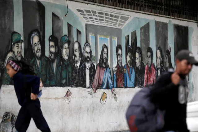 People pass next to a mural depicting the communist leaders at the 23 Enero neighbourhood in Caracas, Venezuela, November 30, 2016. (Photo by Ueslei Marcelino/Reuters)