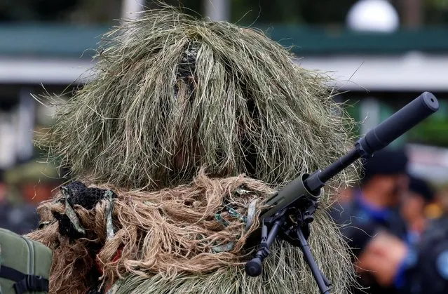 A soldier in a sniper camuoflage holds a weapon before the start of a parade for the change of command for the new Armed Forces chief at a military camp in Quezon City, Metro Manila, Philippines December 7, 2016. (Photo by Erik De Castro/Reuters)