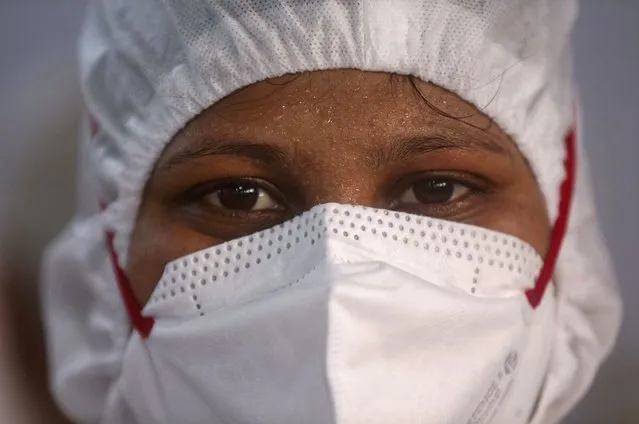 A nurse poses for a photograph inside a ward at the BKC jumbo field hospital, one of the largest COVID-19 facilities in Mumbai, India, Friday, May 7, 2021. (Photo by Rafiq Maqbool/AP Photo)