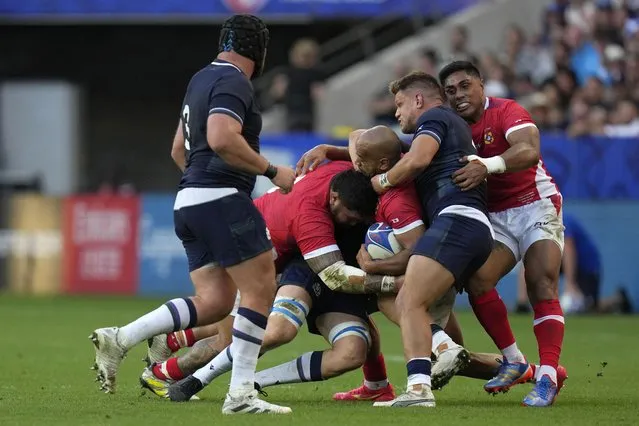 Tonga's Afusipa Taumoepeau, centre, is tackled by Scotland's George Turner during the Rugby World Cup Pool B match between Scotland and Tonga at the Stade de Nice, in Nice, Sunday, September 24, 2023. (Photo by Pavel Golovkin/AP Photo)