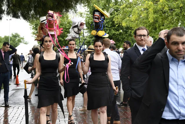 Racegoers arrive before the running of the Melbourne Cup at the Flemington Racecourse in Melbourne, Australia, Tuesday, November 6, 2018. (Photo by Andy Brownbill/AP Photo)