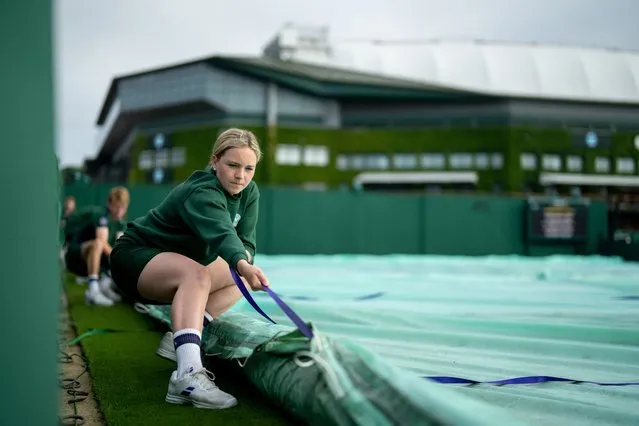 Court Coverers remove the covers on Court 4 during Day Four of The Championships - Wimbledon 2021 at All England Lawn Tennis and Croquet Club on July 01, 2021 in London, England. (Photo by Jed Leicester/AELTC – Pool via Getty Images)