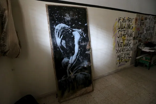 The doorway of a destroyed house, which was painted by British street artist Banksy, is seen inside the gallery of a local Palestinian artist after he bought it from the house's owner, in Khan Younis in the southern Gaza Strip, April 1, 2015. A Palestinian man was lamenting his misfortune on Wednesday after selling his bombed-out doorway to a local artist without realizing that the image painted on it was by Banksy and could be worth a small fortune.  (Photo by Ibraheem Abu Mustafa/Reuters)