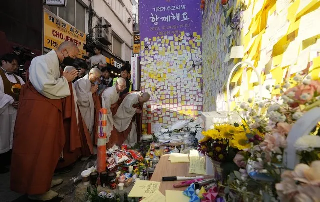 Buddhist monks pray for the victims to mark the first anniversary of the harrowing crowd surge that killed about 160 people in a Seoul alleyway, at the Itaewon district in Seoul, South Korea, Sunday, October 29, 2023. (Photo by Ahn Young-joon/AP Photo)