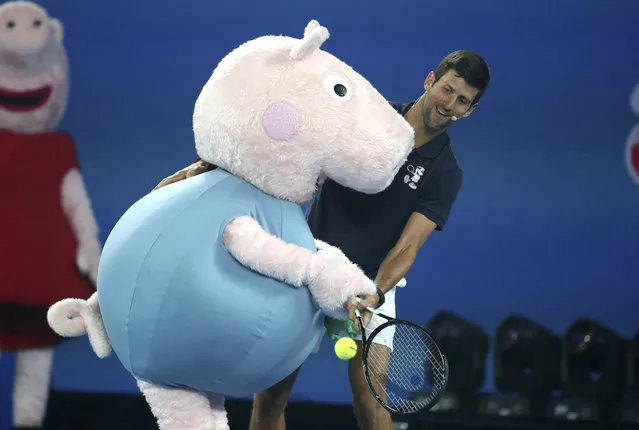 Serbia's Novak Djokovic and Peppa Pig combine to return a shot during Kids Tennis Day ahead of the Australian Open tennis championships in Melbourne, Australia, Saturday, January 12, 2019. (Photo by Mark Schiefelbein/AP Photo)