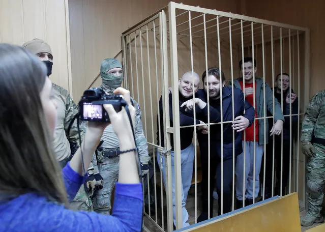 Detained crew members of Ukrainian naval ships, which were seized by Russia's FSB security service in November 2018, pose for a picture inside a defendants' cage as they attend a court hearing in Moscow, Russia January 15, 2019. (Photo by Maxim Shemetov/Reuters)