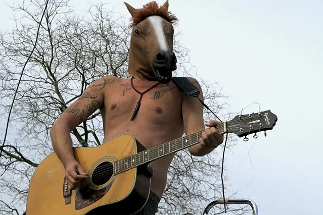 An artist wearing a mask of a horse head performs at the Mauer Park in Berlin April 12, 2015. (Photo by Pawel Kopczynski/Reuters)