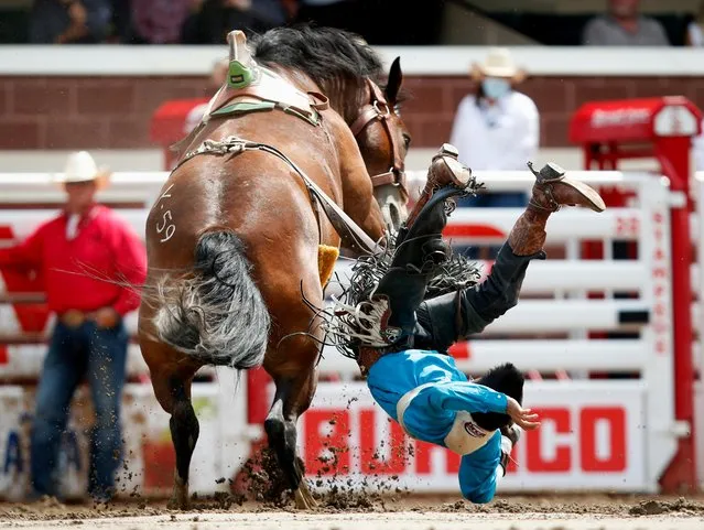 Evan Betony of Tonalea, Arizona, gets tossed off the horse Young Carma in the bareback event during the rodeo as the Calgary Stampede gets underway following a year off due to coronavirus disease (COVID-19) restrictions, in Calgary, Alberta, Canada July 11, 2021. (Photo by Todd Korol/Reuters)