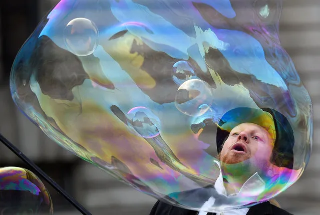 A street artist performs with giant soap bubbles outside the Natural History Museum in London, Britain, December 12, 2017. (Photo by Clodagh Kilcoyne/Reuters)